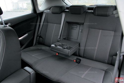 База машины увеличилась на 71 мм, но к числу лидеров по запасу пространства для ног задних пассажиров Астра не относится — во всяком случае, здесь не просторнее, чем в Гольфе. Подушка сиденья низкая, тонкая и жесткая, зато места над головой предостаточно