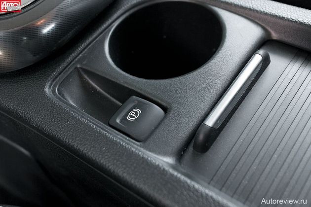 На месте прежнего рычага «ручника» у Астры теперь подстаканник, ниша для мелочовки и маленькая клавиша, управляющая электромеханическим приводом стояночного тормоза