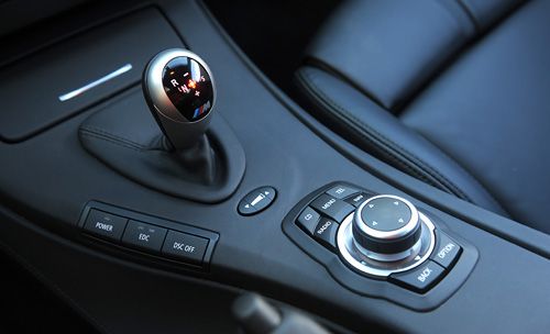 Возле рычага КПП — селектор выбора скорости переключения передач, кнопки управления системой стабилизации, мотора и активных амортизаторов, а также шайба айдрайва