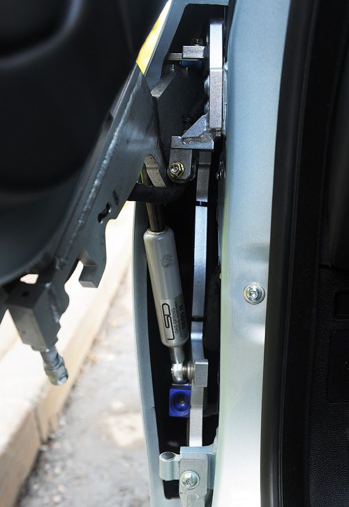 Механизм вертикального открывания дверей от немецкой фирмы LSD работает так себе: дверь сначала нужно открыть как обычно на небольшой угол (дальше открыть её «по нормальному» уже нельзя — мешает ограничитель), и уже потом толкнуть её вверх. Люфты большие, а усилия надо прикладывать не детские. И не женские