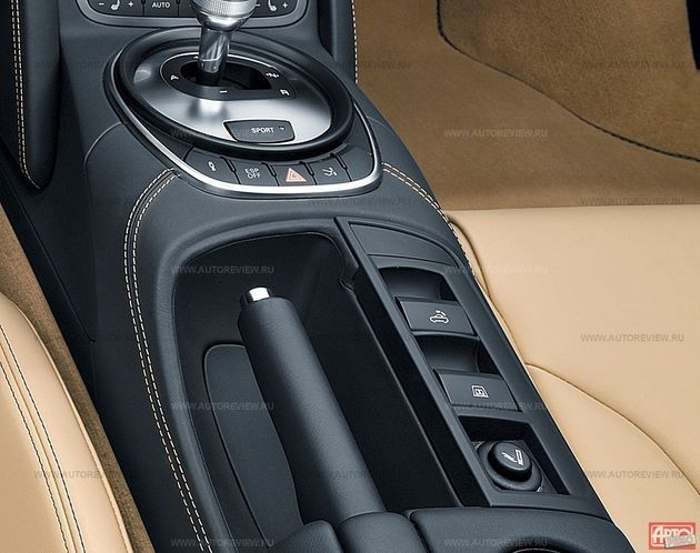 Клавиши управления крышей и задним стеклом находятся там, где у купе R8 была пепельница. Чтобы сложить крышу во время стоянки, клавишу нужно удерживать в течении всего процесса, а на скорости свыше 6 км/ч достаточно одного нажатия